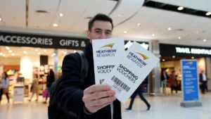 UK traveller holding Heathrow Rewards shopping vouchers at Heathrow Airport